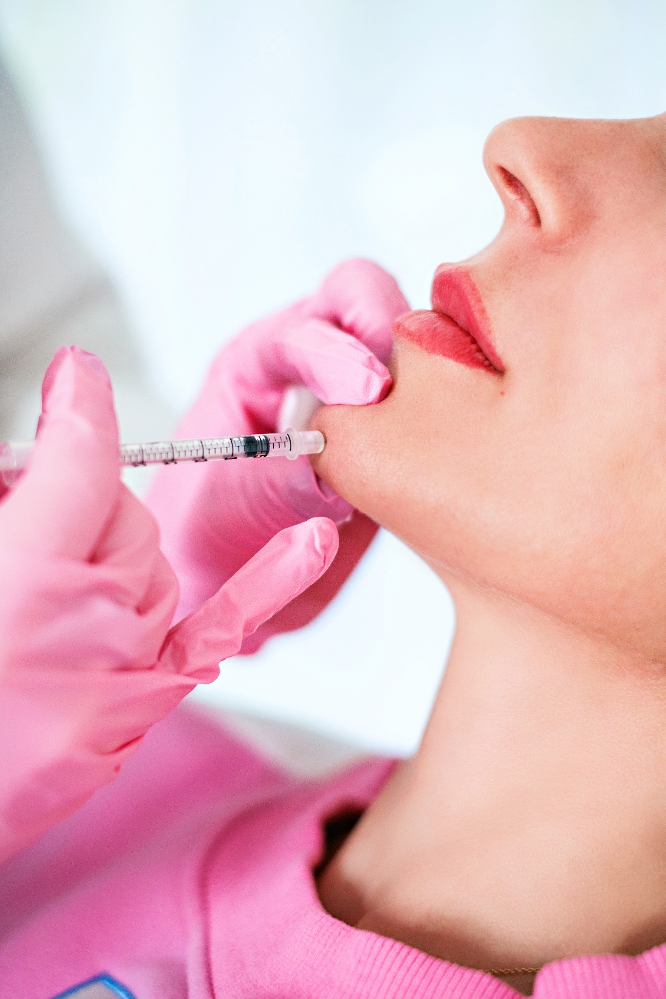Close-up profile of a patient receiving a precise injectable treatment from a provider wearing pink gloves